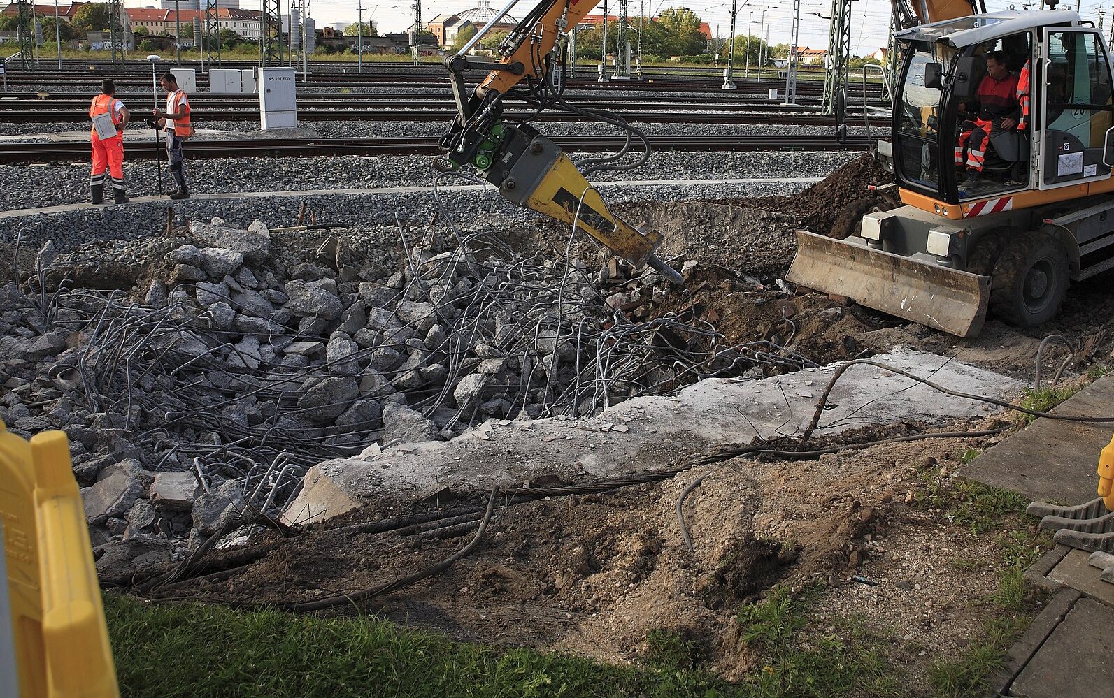 Hydraulic breaker working over a pile of broken concrete slab
