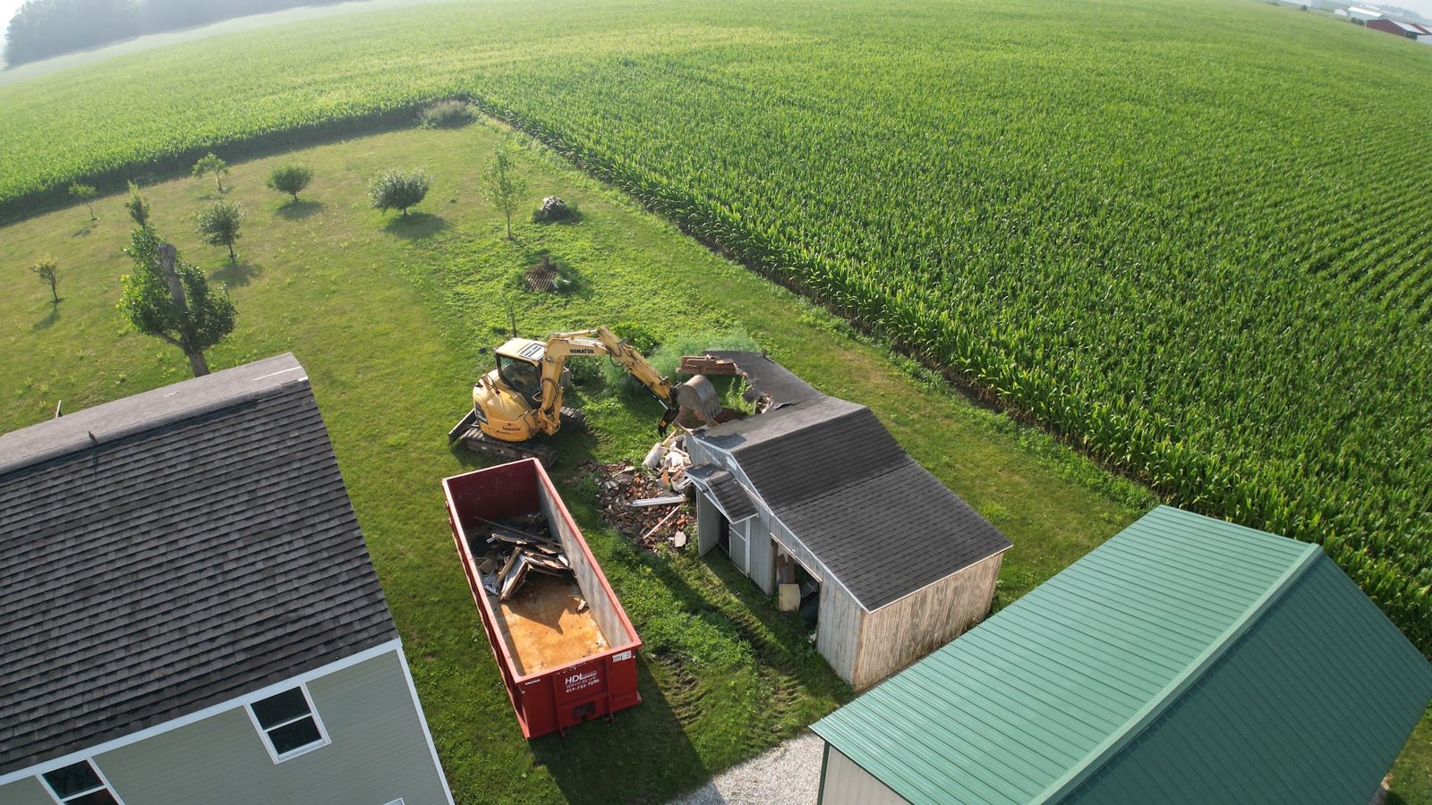 Patterson Dirtscapes shed demolition in progress with dumpster on site